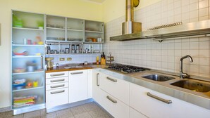 A kitchen with white cabinets, a stainless steel range, a double sink, and a built-in oven. - 2 bedroom cozy apartment in Orbetello (Orbetello)