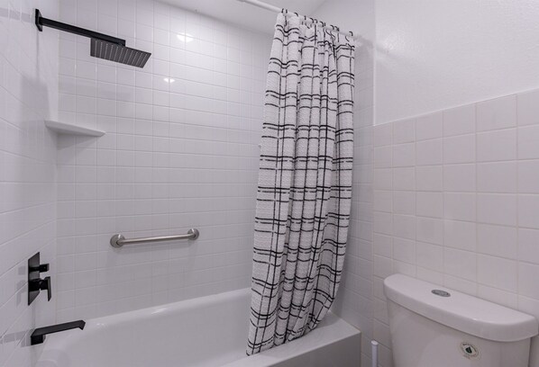 A bathroom with a white bathtub, a showerhead, a toilet, and a towel rack. - *Oct/Nov Special*Pool~ASU~Long Stays~Sundevil Stay (Tempe)