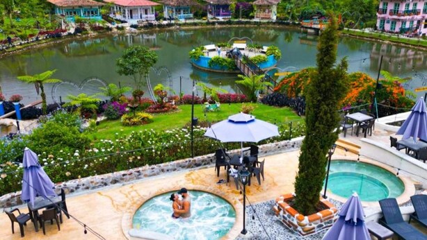 Ein Resort mit Schwimmbad, Liegestühlen und einem Garten.