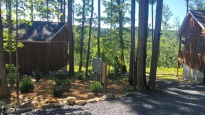 Two wooden cabins surrounded by a forest with a gravel path and small rocks. - Boho Getaway for Two, Stay near the New River Gorge and Glade Creek Farm (Cool Ridge)
