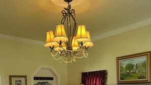 Une chambre d’hôtel avec un grand lit, un lustre, un tableau et un porte-manteau.