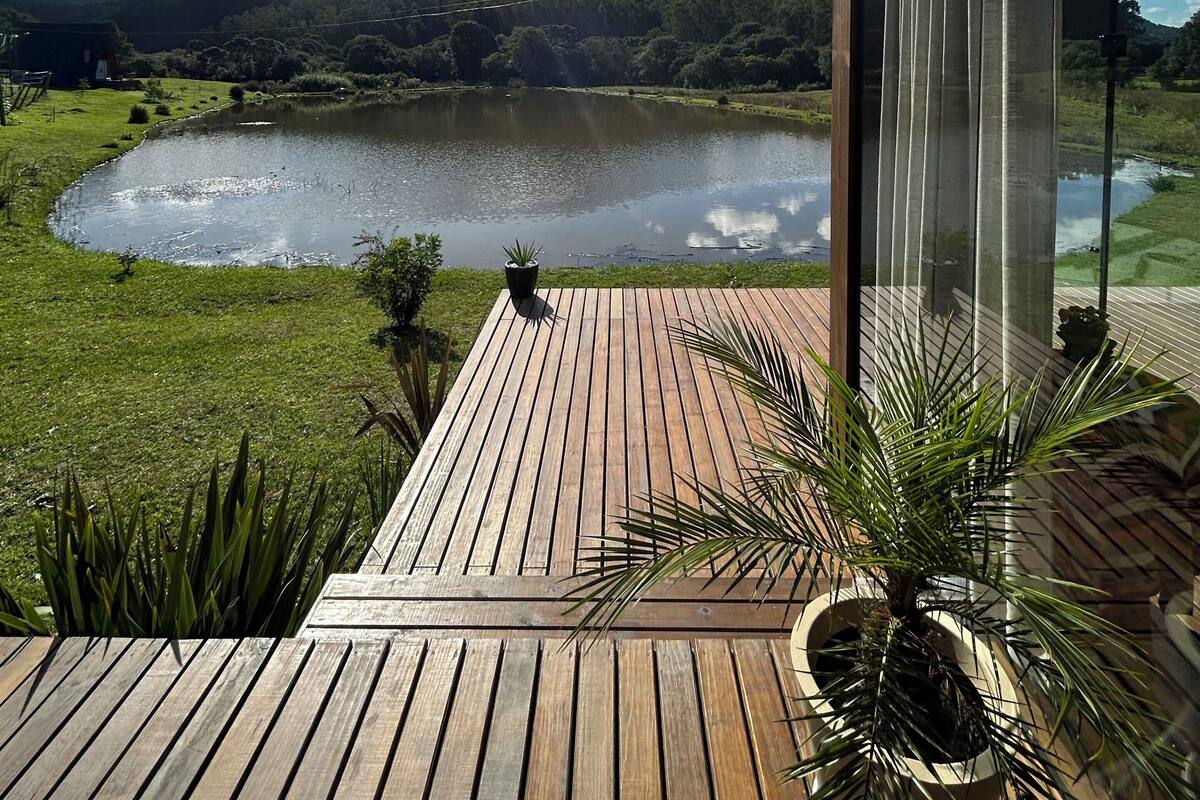 A wooden deck with a view of a lake and mountains.