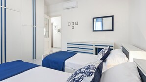 A hotel room with two beds, a wardrobe, a mirror, and a small window. - Casa Giovanna by Wonderful Italy (Bari)