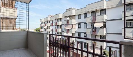 A balcony with a view of a row of modern apartment buildings.