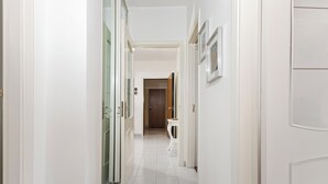 A hallway with white walls, a tiled floor, and a door at the end. - Casa Giovanna by Wonderful Italy (Bari)