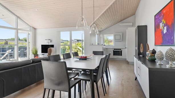 Una cocina moderna con comedor, ventanas amplias y vistas al exterior.