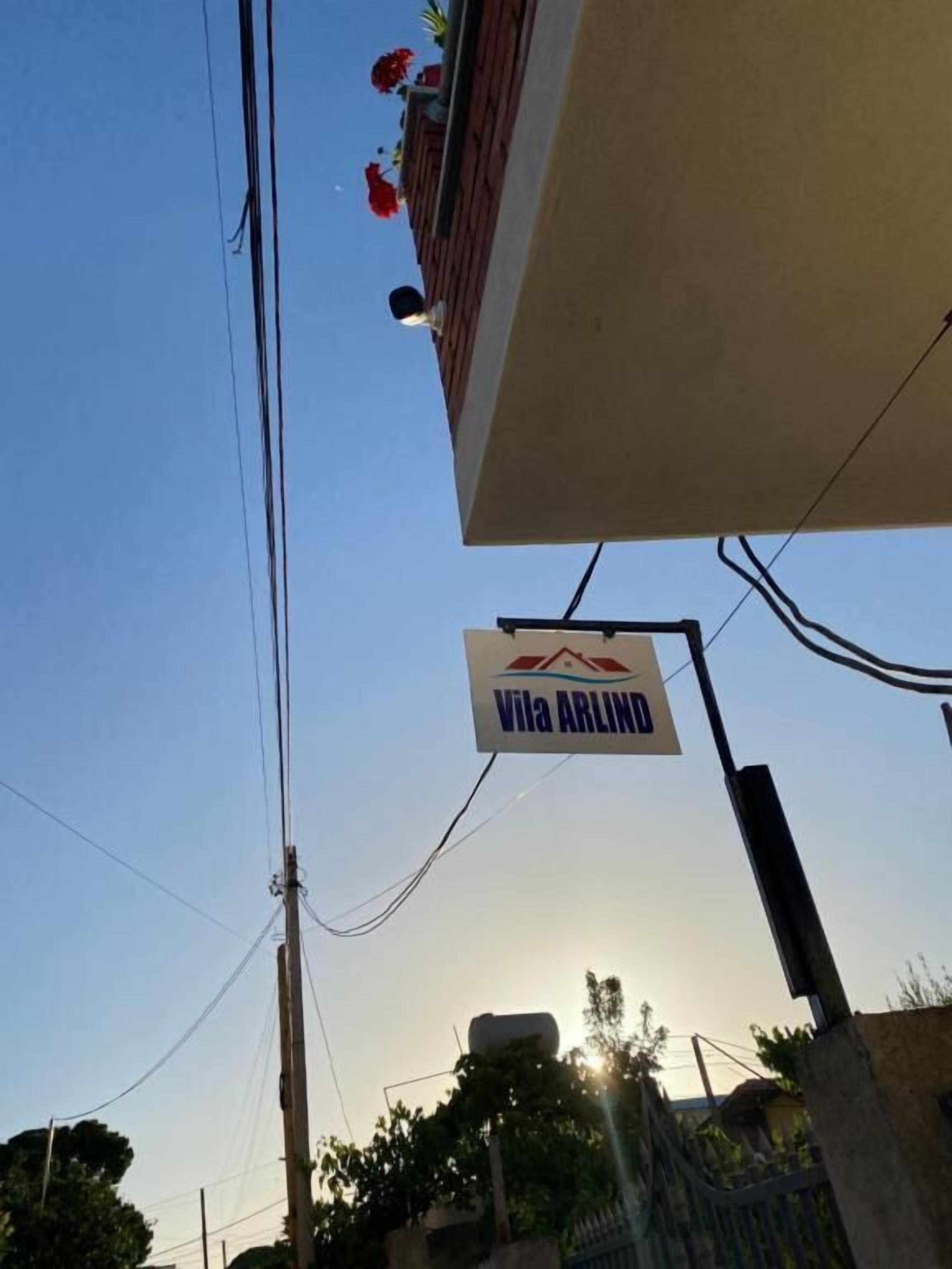 Señal de Vila ARLIND, un hotel con vista despejada al cielo y líneas eléctricas en la parte superior.