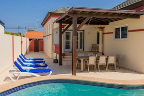 A pool area with lounge chairs and a covered patio with a table and chairs. - Sleeps 11 6 Bedrooms Privatepool Outdoor Dining (Noord)