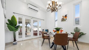 A dining area with a round table, brown chairs, and potted plants. - Sleeps 11 6 Bedrooms Privatepool Outdoor Dining (Noord)