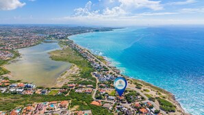 Vista aérea de uma área costeira, com uma combinação de edifícios residenciais e paisagens naturais.