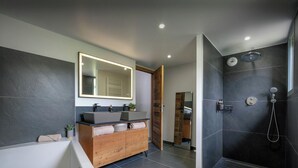 A modern bathroom with a bathtub, two sinks, a large mirror, and a shower area. - Chalet Emeraude des Alpes - peaceful break in the mountains - OVO Network (Saint-Pierre-d'Entremont)