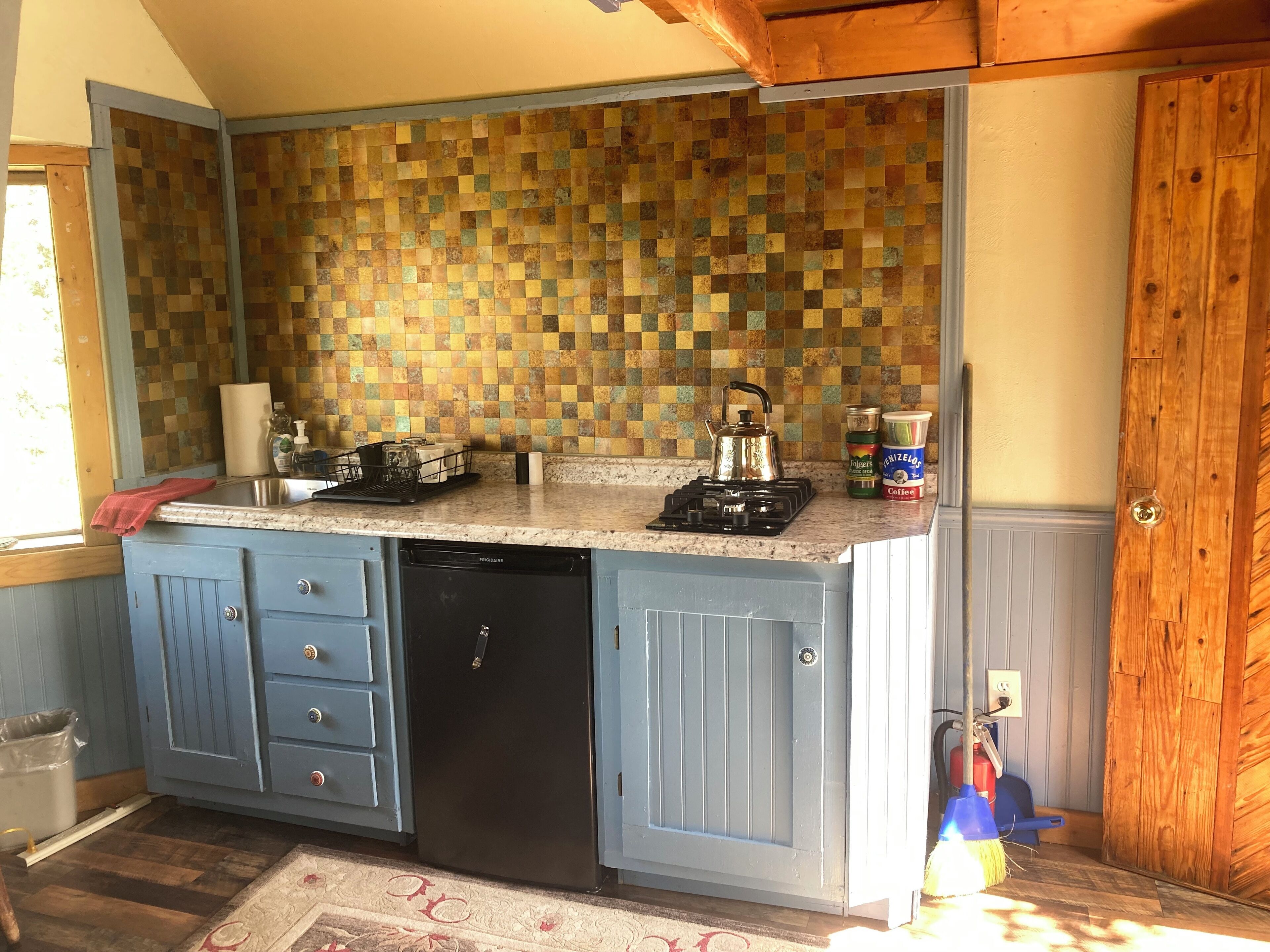 Een waterkoker, kookgerei, borden en bestek, keukenrol