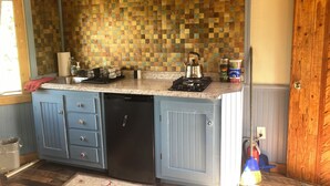 A kitchen with a checkered backsplash, a gas stove, and a dishwasher.