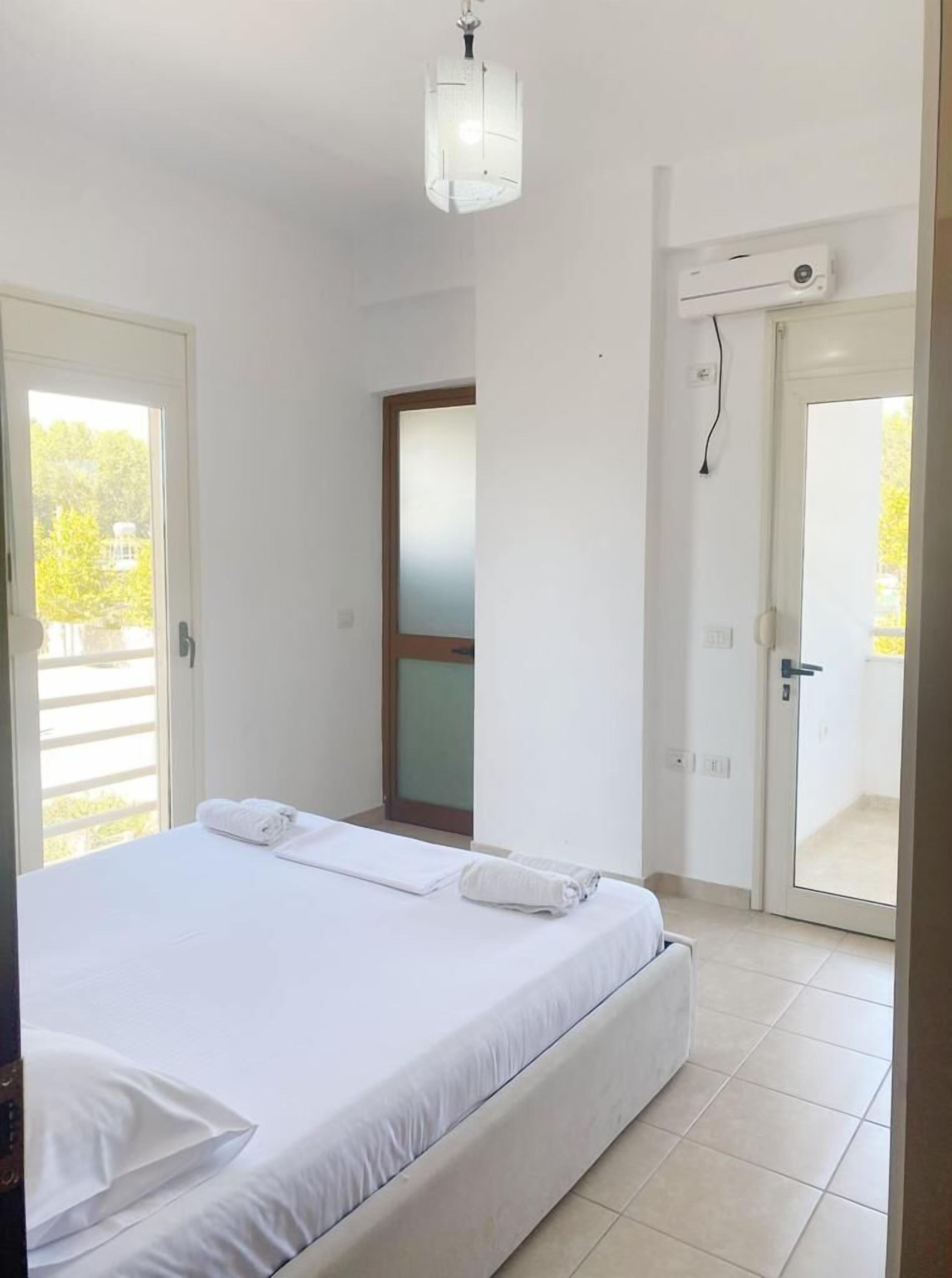 Une chambre à coucher avec un lit, une porte et une vue sur l’extérieur.