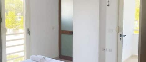Une chambre à coucher avec un lit, une porte et une vue sur l’extérieur.