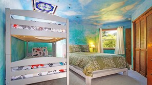 A bunk bed room with a mural of clouds on the ceiling, a window with curtains, and a bedside lamp.