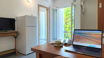 Apartamento, vistas parciales al mar | Zona de estar | Una televisión