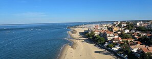A coastal town with a beach, buildings, and boats.
