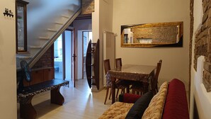Ein Essbereich mit Tisch, Stühlen, einer Bank und einer Couch.