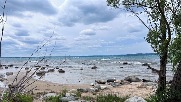 Une plage rocheuse parsemée de gros blocs et où la végétation est rare.