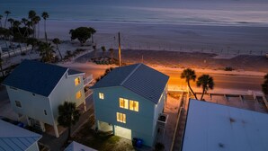 Una zona residenziale sul lungomare, con case, una spiaggia e una strada.