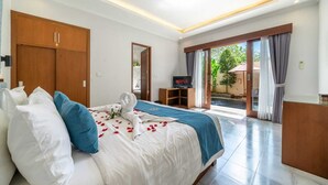 Ein Hotelzimmer mit Bett, Fernseher, Schreibtisch und Blick ins Freie.