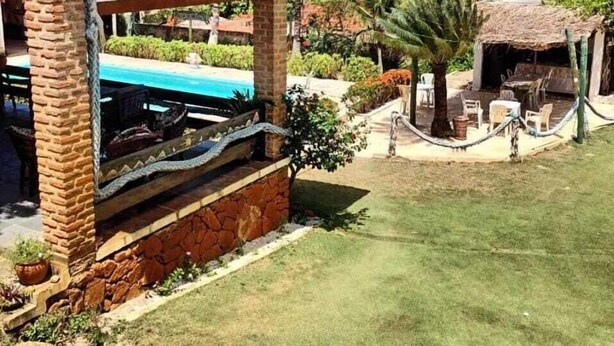 A beachfront property with a covered patio, a pool, and a dining area. - Pousada Sol Nascente (Beberibe)