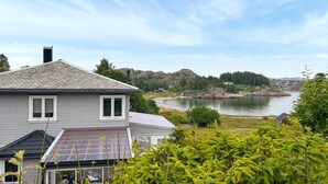 A house with a grey exterior, a tiled roof, and a solar panel on the roof. - Cozy home in Hellvik with WiFi (Hellvik)