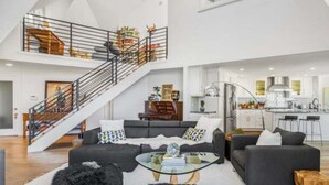 Un vaste espace de vie comprenant un escalier, une cuisine et un coin repas.