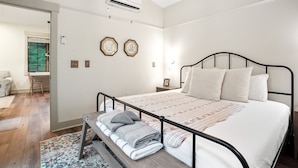 Een slaapkamer met een bed, nachtkastje en een bank met handdoeken.