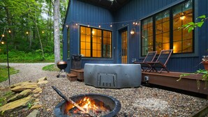 Een vakantiehuis met vuurkorf, buitenmeubels en een terras.