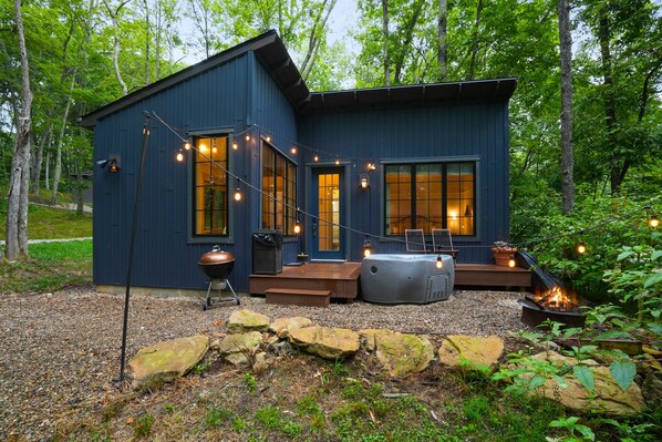 A modern cabin with large windows, a deck, and a fire pit. - Evermore Cottage | Hocking Hills, Couples Retreat (Creola)