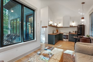 Una cocina moderna con una isla central, electrodomésticos integrados y un comedor con mesa y sillas.