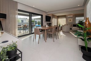 Relax in this spacious living area with a large dining table, comfortable sofa, and flat-screen TV.
