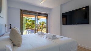 A hotel room with a bed, a ceiling fan, a TV mounted on the wall, and a view of the outdoors. - Ref. 421409 (Estepona)