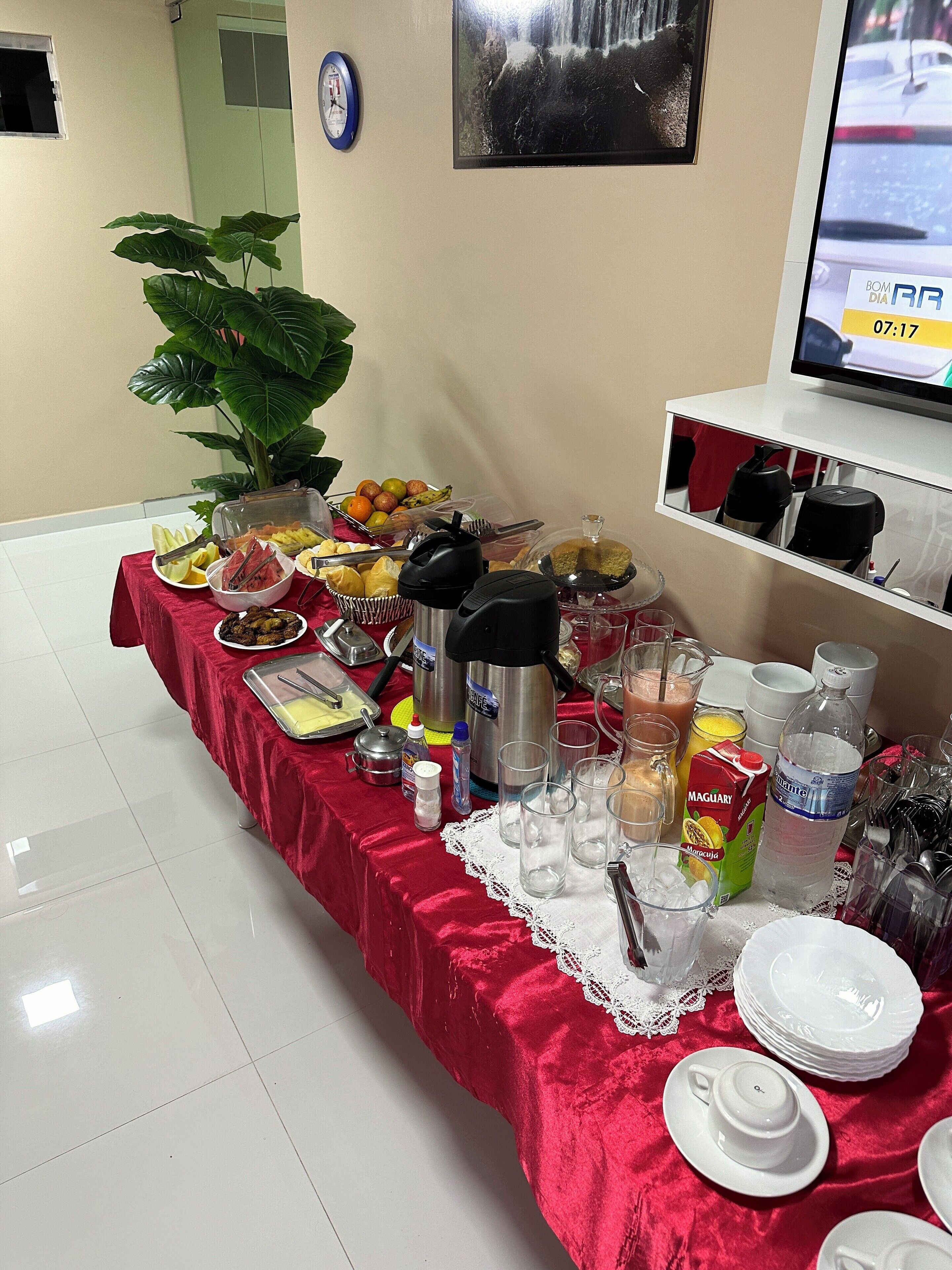 Ein Buffet mit verschiedenen Speisen, einer Uhr und einem Fernseher, der die Uhrzeit anzeigt.