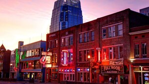 A street lined with brick buildings, including a record shop and a bar.