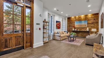 A spacious living room with a wooden floor, a sofa, a coffee table, and a fireplace.