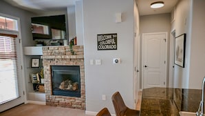 A living room with a fireplace, a television, and a sign that reads "WELCOME TO COLORFUL COLORADO". - Cozy Granby Escape: Ski, Hike & Relax (Granby)
