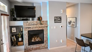 A living room with a fireplace, a flat-screen TV mounted above it, and a sign on the wall that reads "WELCOME TO COLORFUL COLORADO". - Cozy Granby Escape: Ski, Hike & Relax (Granby)