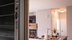 A modern kitchen with a stone fireplace, a sink, and a countertop. - Cozy Granby Escape: Ski, Hike & Relax (Granby)