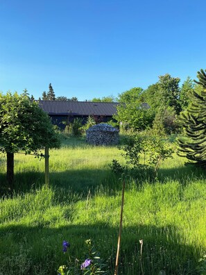 A traditional building with a tiled roof, surrounded by lush greenery and trees. - Holiday home close to the beach in Nødebohuse (Hundested)