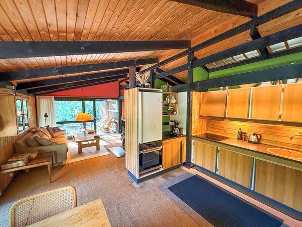 Ein gemütliches Blockhaushaus-Interieur mit Wohnbereich, Küchenzeile und Essplatz.