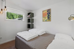 Un dormitorio con cama, ventana, estantería y un cartel en la pared.