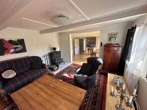A living room with a sofa, armchair, wooden coffee table, and a patterned rug.