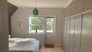 A bedroom with a bed, a window, a door, and a wardrobe. - Holiday Flat in Skagen town (Skagen)