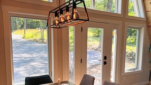 A dining area with a wooden table, six chairs, and a modern pendant light fixture.