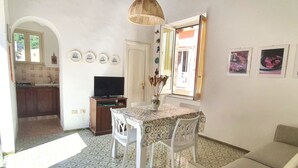 Espaço compacto com área de refeições, cozinha compacta e televisão.