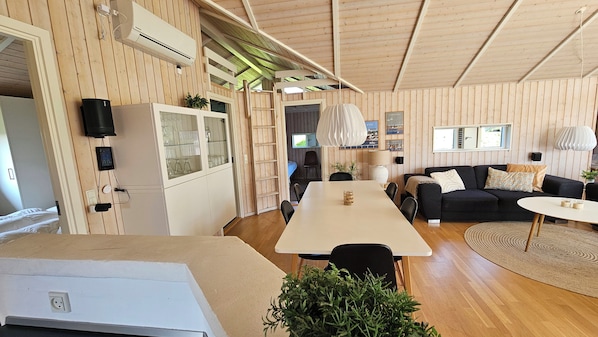 A compact living space with a kitchenette, a dining area, and a seating area with a sofa and a coffee table.