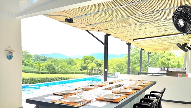 A dining area with a pool view, outdoor seating, and a fan. - Excepcional CASA FINCA piscina wi-fi tv (Tocaima)